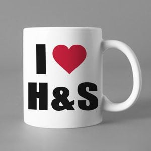 Na obrazku jest przedstawiony biały ceramiczny kubek z napisem "Kocham H&S" - Dni bezpieczeństwa BHP Proresult