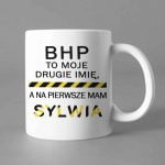 Na obrazku jest przedstawiony biały ceramiczny kubek z nadrukiem " BHP to moje drugie imię..." - Gadżety BHP Proresult