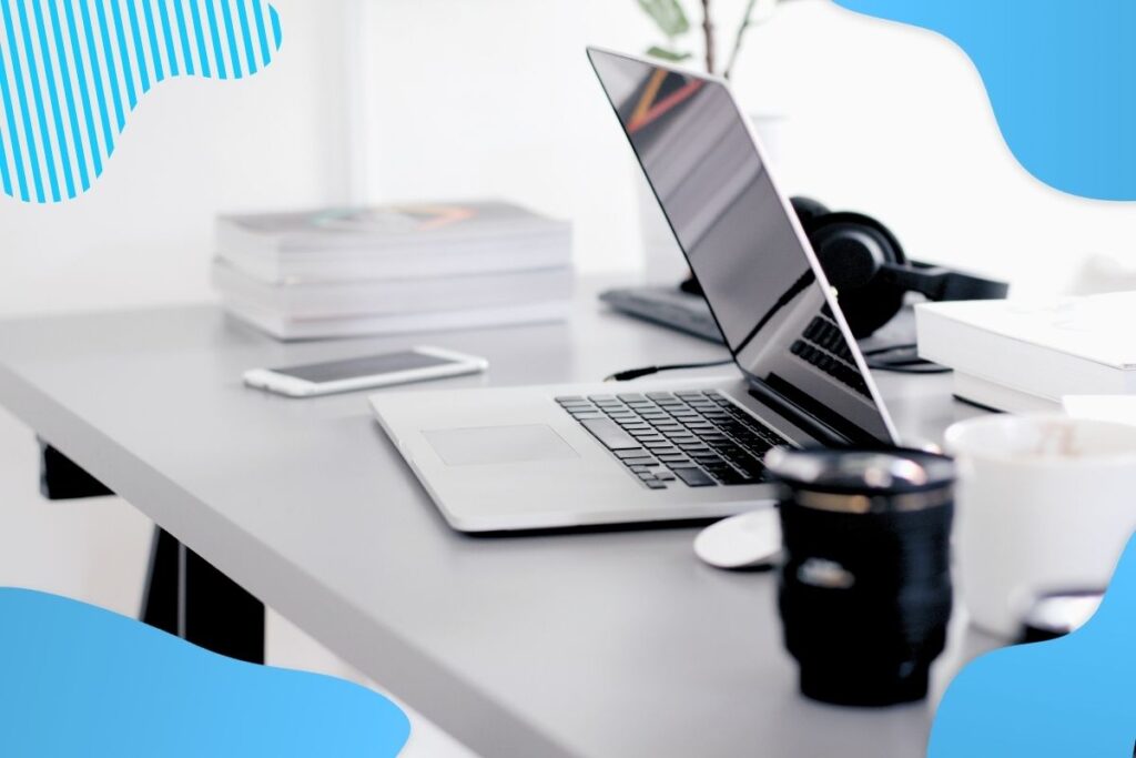 Na szarym biurku stoi laptop, a bok niego czarny termos z kawą - szkolenia bhp online Proresult