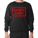 Na obrazku przedstawiona jest czarna bluza z czerwonym napisem SAFETY FIRST - Bluzy BHP Proresult