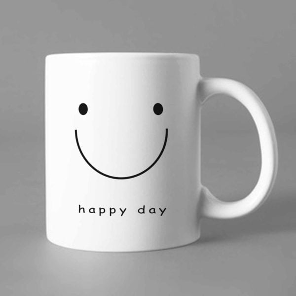 Na obrazku przedstawiony jest biały ceramiczny kubek z nadrukowanym uśmiechem i napisem happy day - Wellbeing BHP Proresult