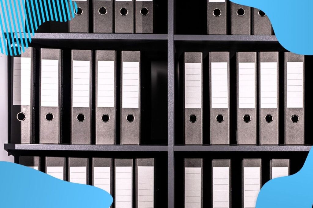 Szare segregatory stoją na szafie w dwóch rzędach - materiały szkoleniowe BHP Proresult