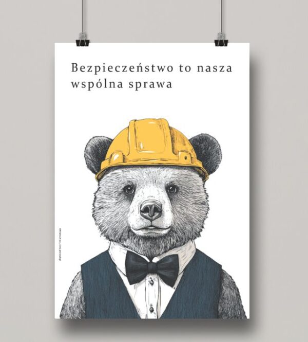 Na obrazku widać zawieszony minimalistyczny plakat z misiem w kasku oraz hasłem w języku polskim - Plakaty BHP Proresult